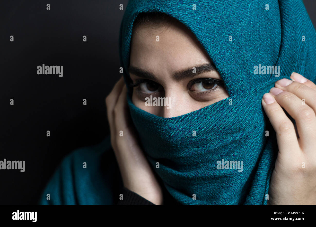 Musulmani bella ragazza in hijab. Ritratto di un giovane arabo donna su uno sfondo nero. Foto Stock