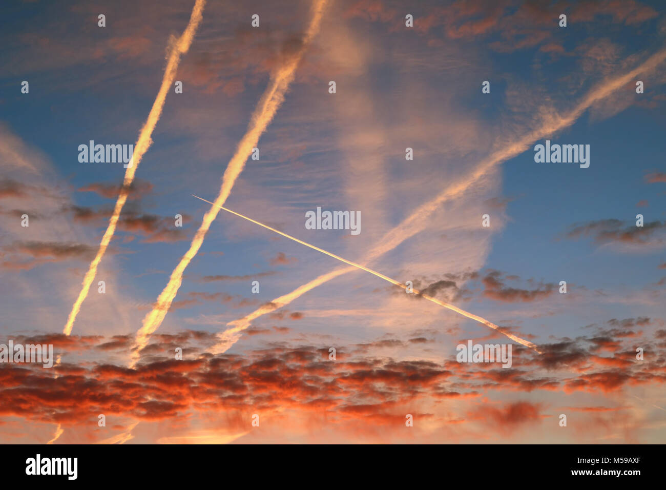 La mattina di rosso le nuvole e flussi di vapore condensato sul cielo Foto Stock