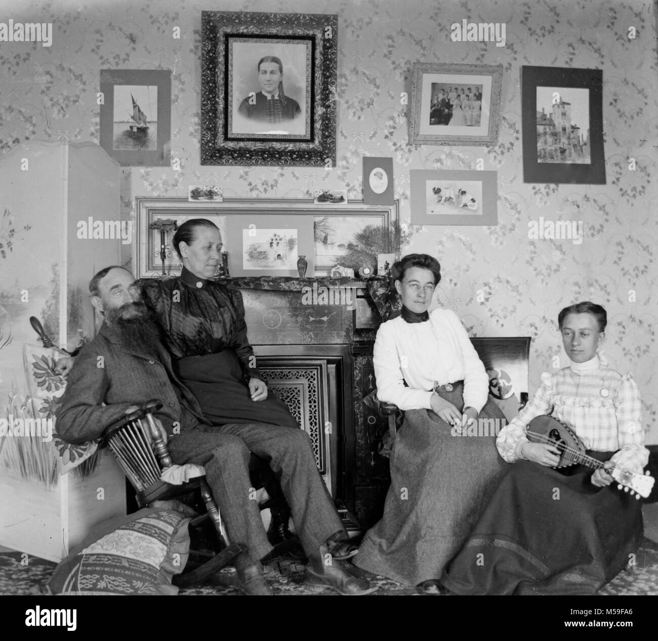 Mandolino musica è eseguita nella stanza di seduta per la famiglia estesa, ca. 1900. Foto Stock