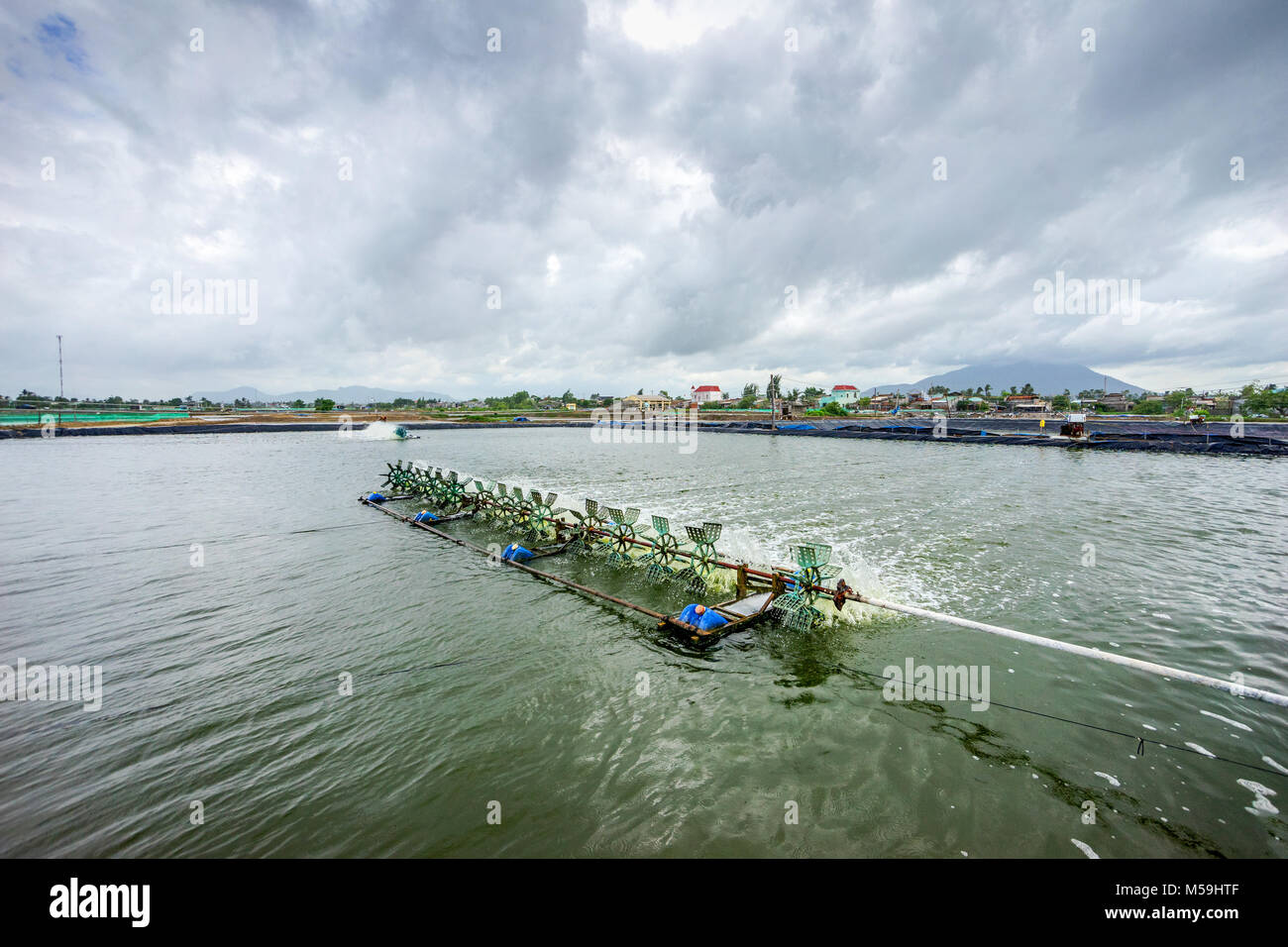 * Aeratore ruota di turbina ossigeno ins di riempimento nel lago di acqua in allevamento di gamberetti in Ba Ria, Vung Tau, Vietnam Foto Stock