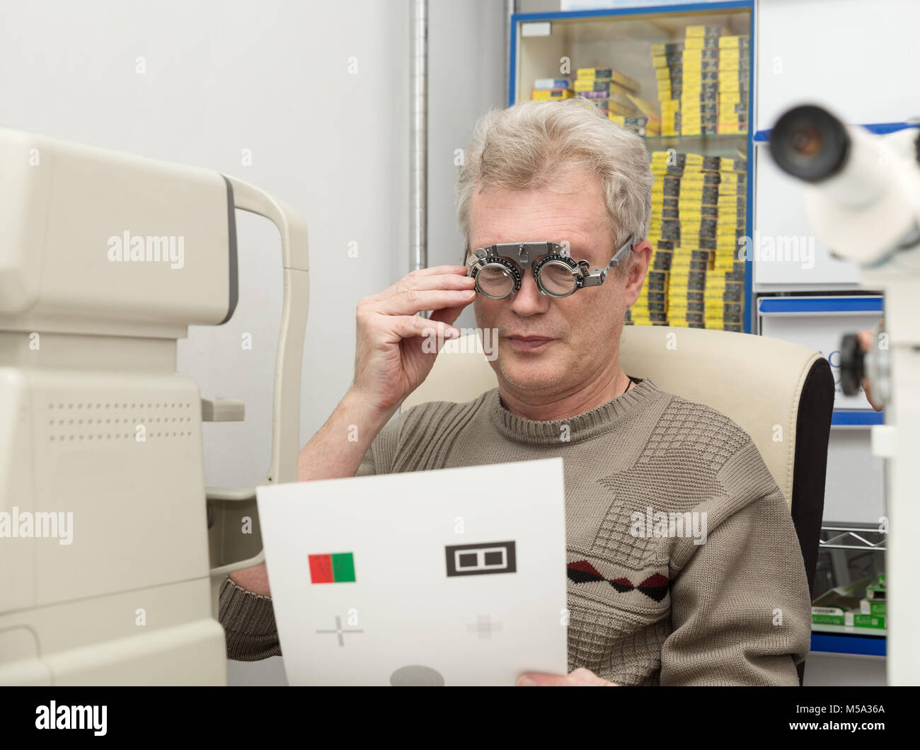 Un uomo maturo controlla la vista in una clinica oftalmica Foto Stock