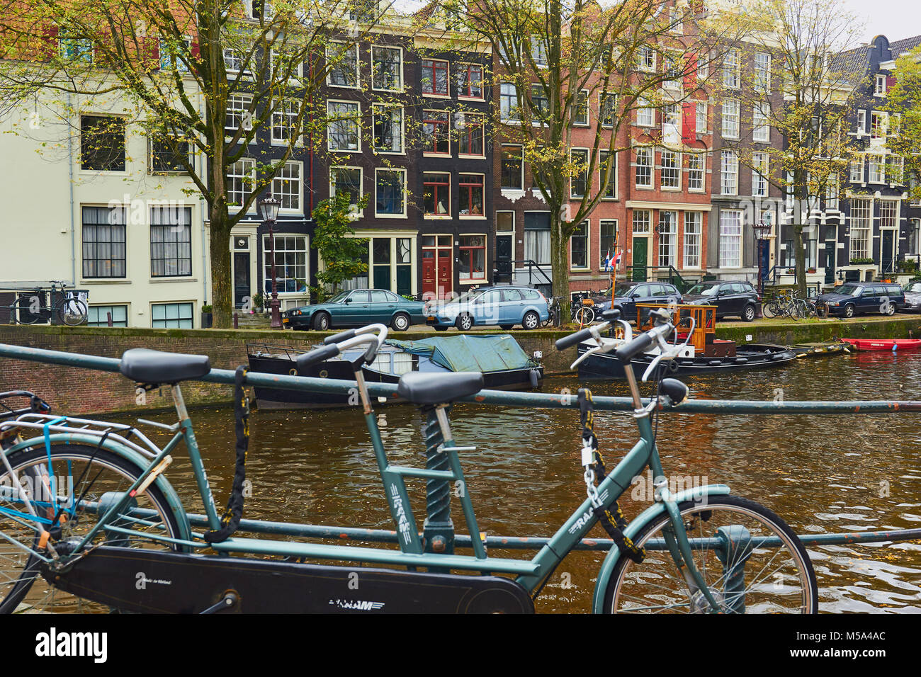 Biciclette Tandem incatenato al di sopra di canal, Amsterdam, Paesi Bassi Foto Stock