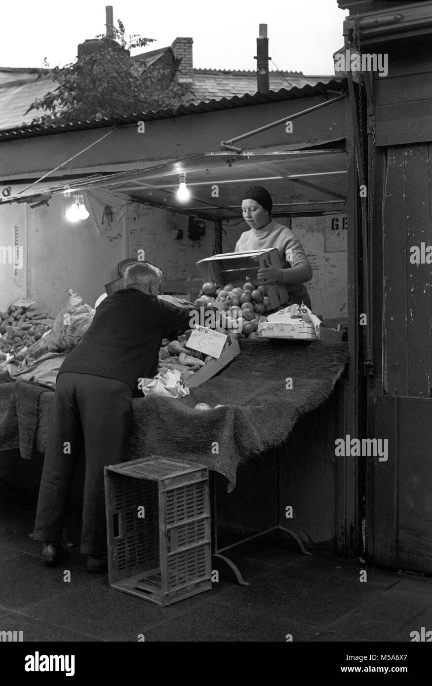 Regno Unito, Galles Cardiff City Centre, Hayes, vecchio Cardiff apertura del mercato di frutta e verdura in stallo la mattina presto la preparazione per aprire, prima di demolizione negli anni settanta Foto Stock