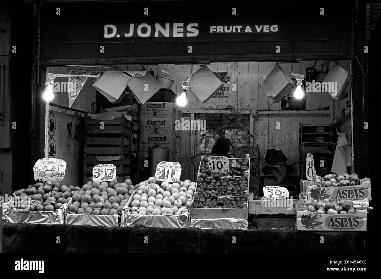 Regno Unito, Galles Cardiff City Centre, Hayes, vecchio Cardiff mercato aperto, D' Jones di frutta e verdura in stallo la mattina presto la preparazione per aprire, prima di demolizione negli anni settanta Foto Stock