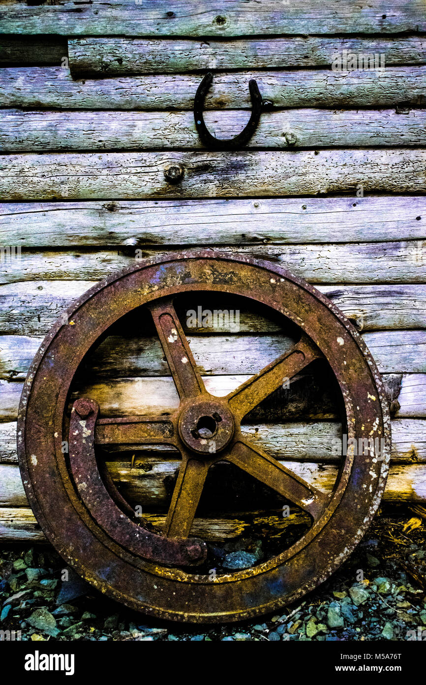 Ruota di carro su uno sfondo di legno con il ferro di cavallo. Foto Stock