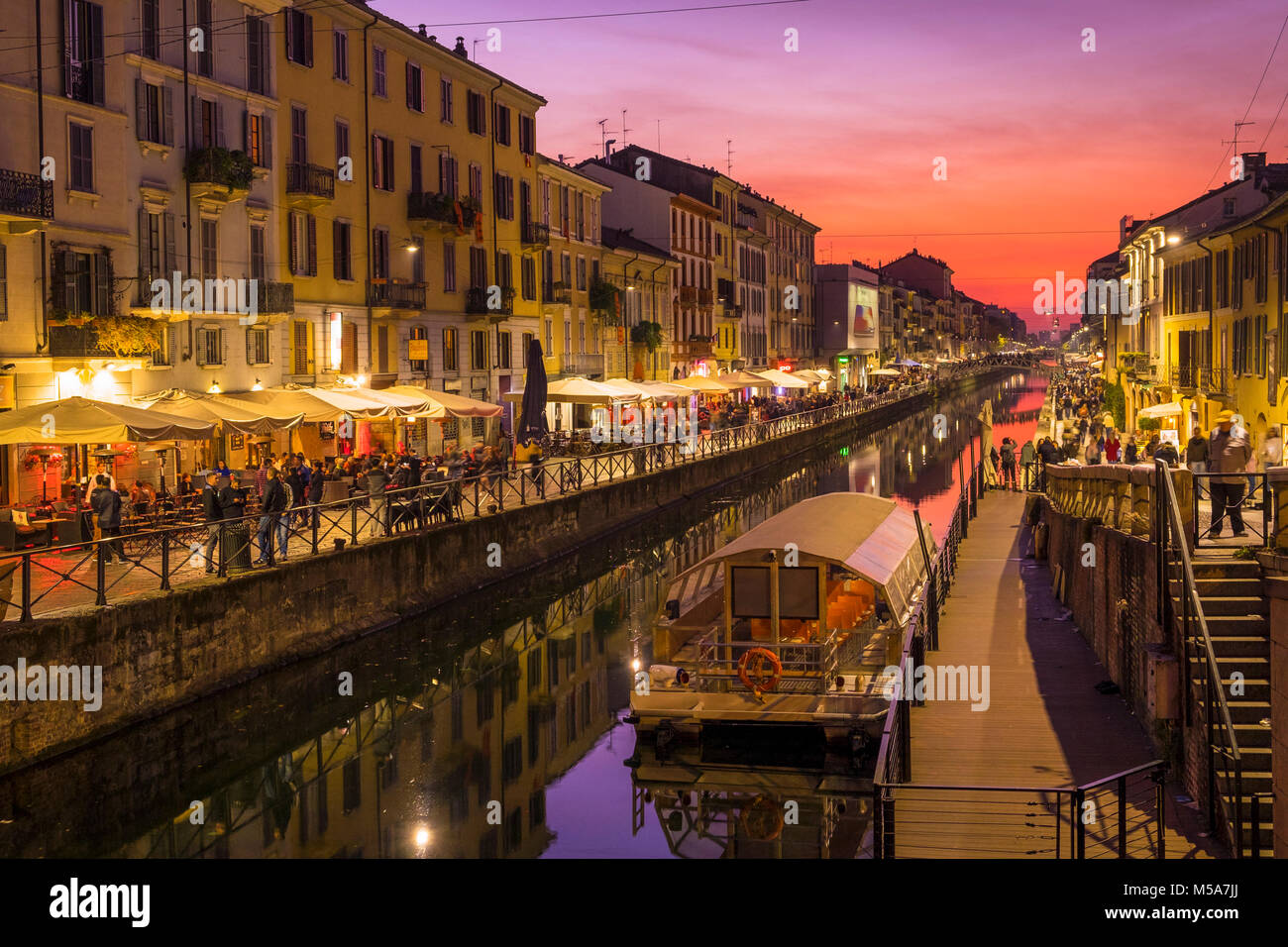 Naviglio Grande canal con ristoranti e turisti in Milano, Italia la sera Foto Stock