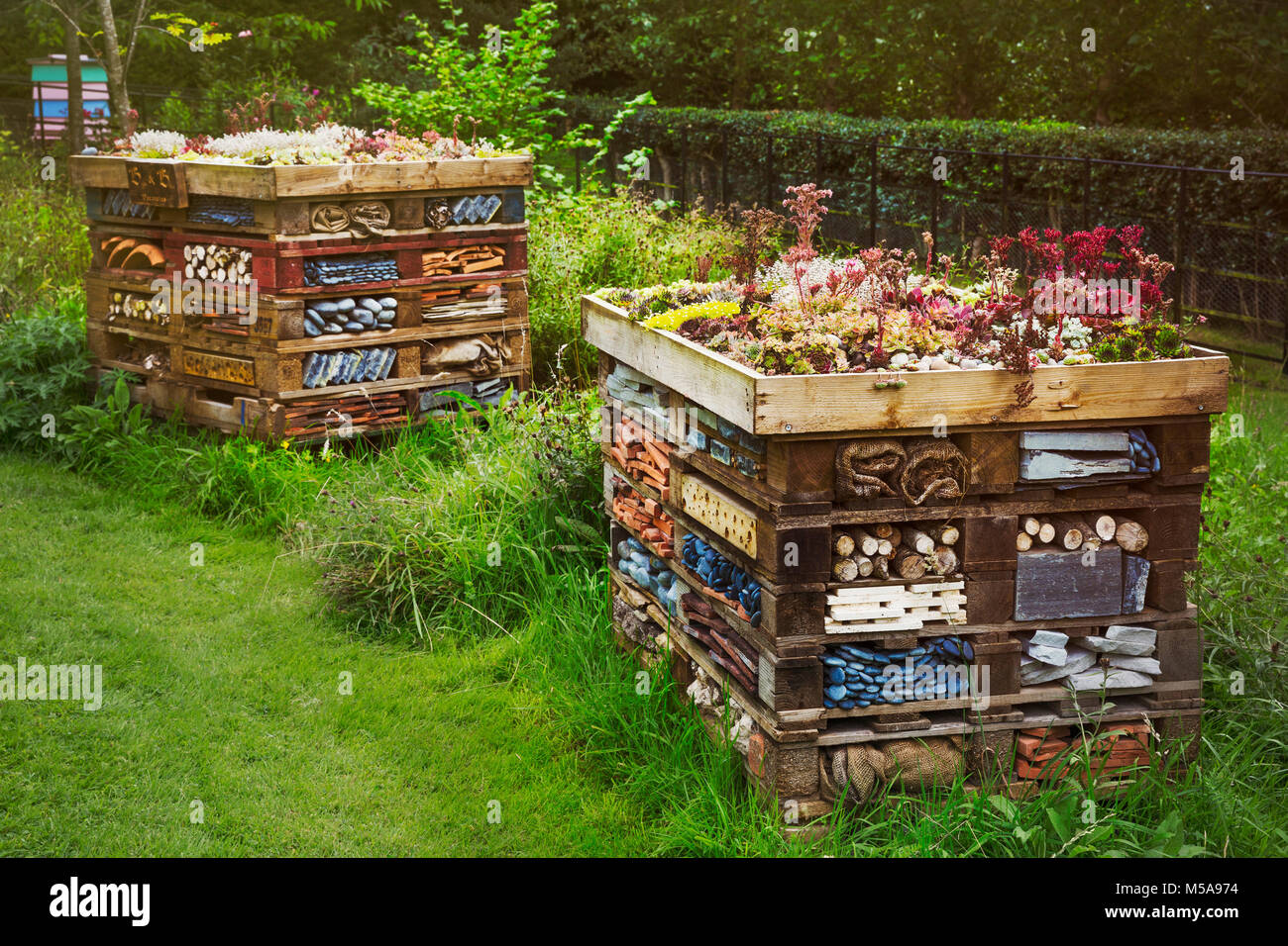 Due grandi case di bug con diversi strati di materiali differenti in un giardino. Foto Stock