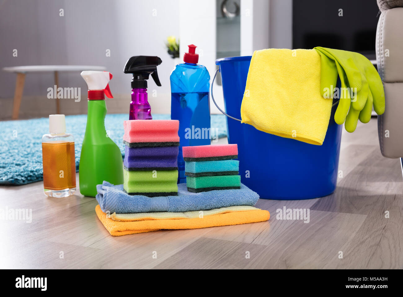 Colore blu secchio con attrezzature di pulizia su pavimento in legno duro Foto Stock