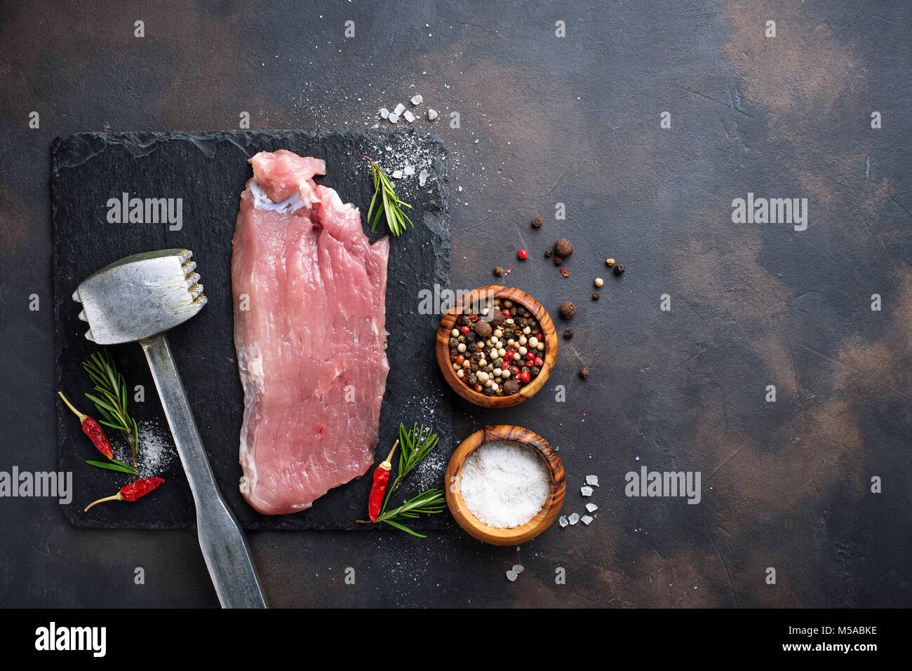 La carne cruda di manzo con spezie su sfondo arrugginito Foto Stock