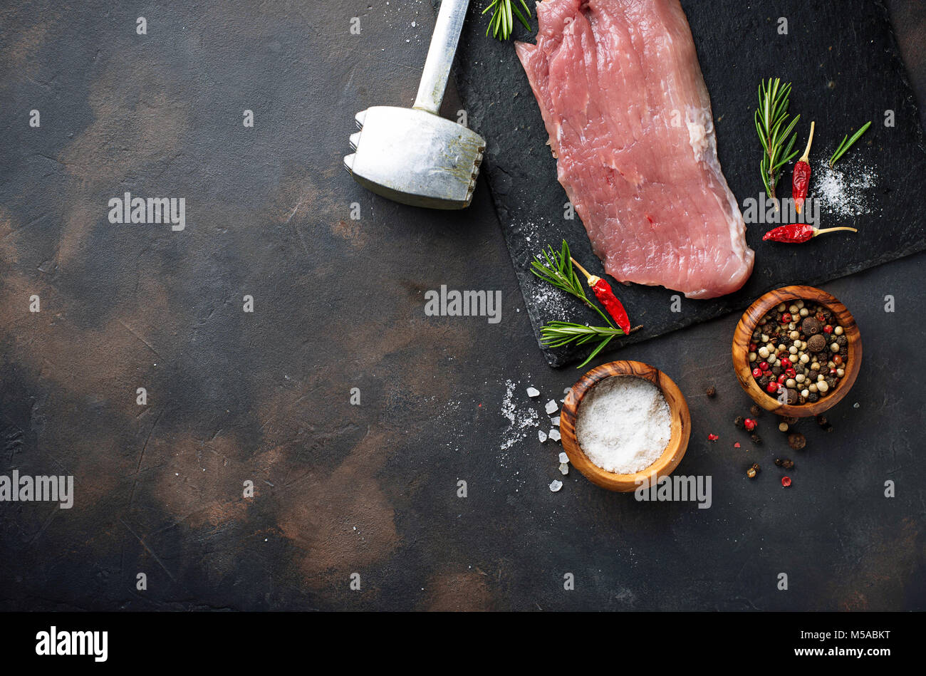 La carne cruda di manzo con spezie su sfondo arrugginito Foto Stock