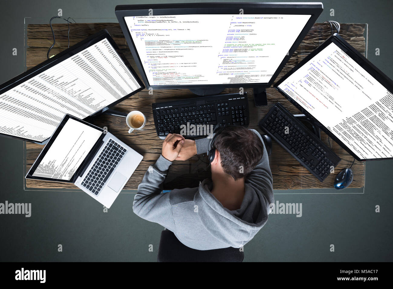 Vista in elevazione dell uomo dorme con più computer e laptop sulla scrivania Foto Stock