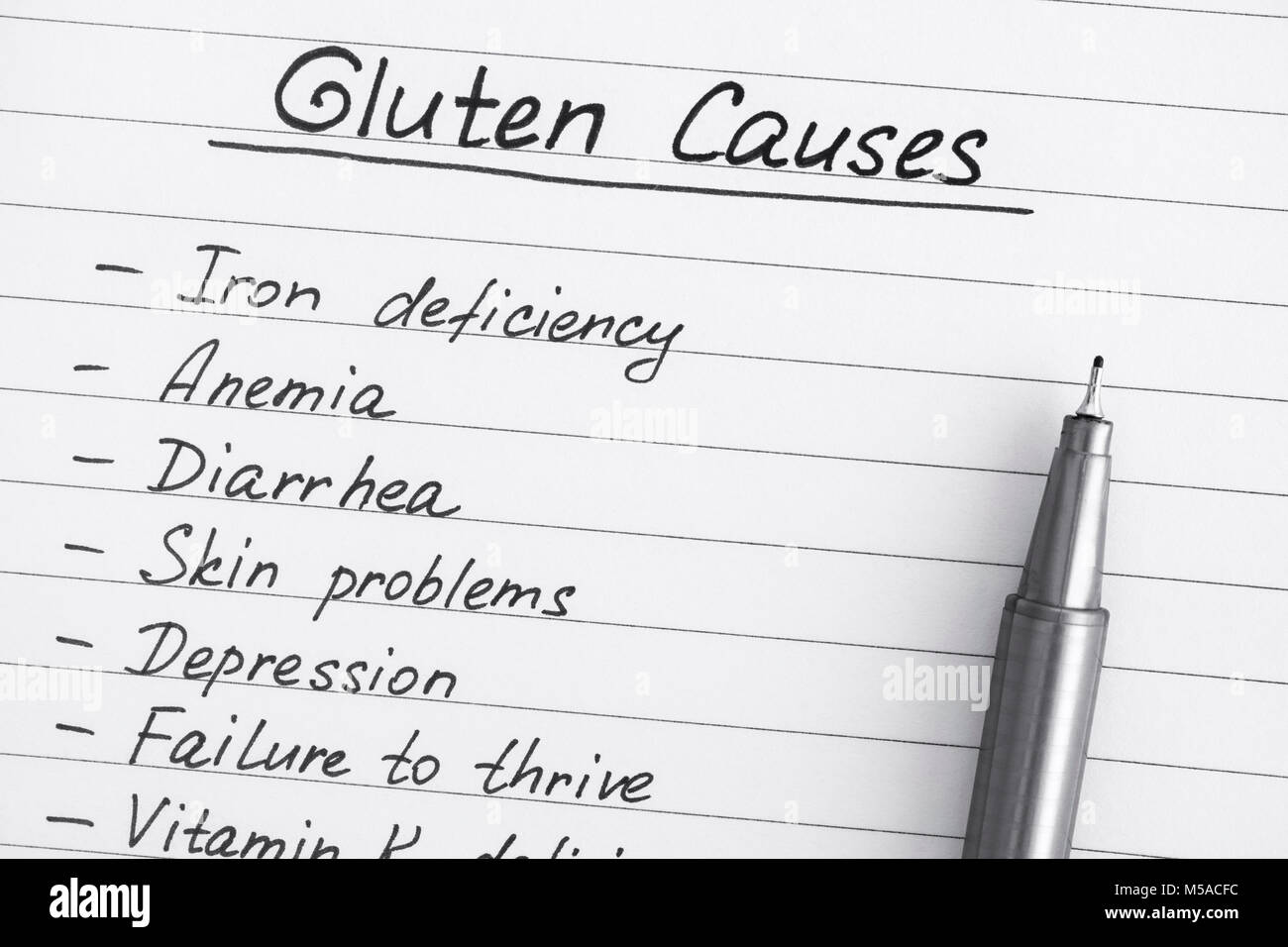 Elenco delle cause di glutine con la penna. Close-up. Foto Stock