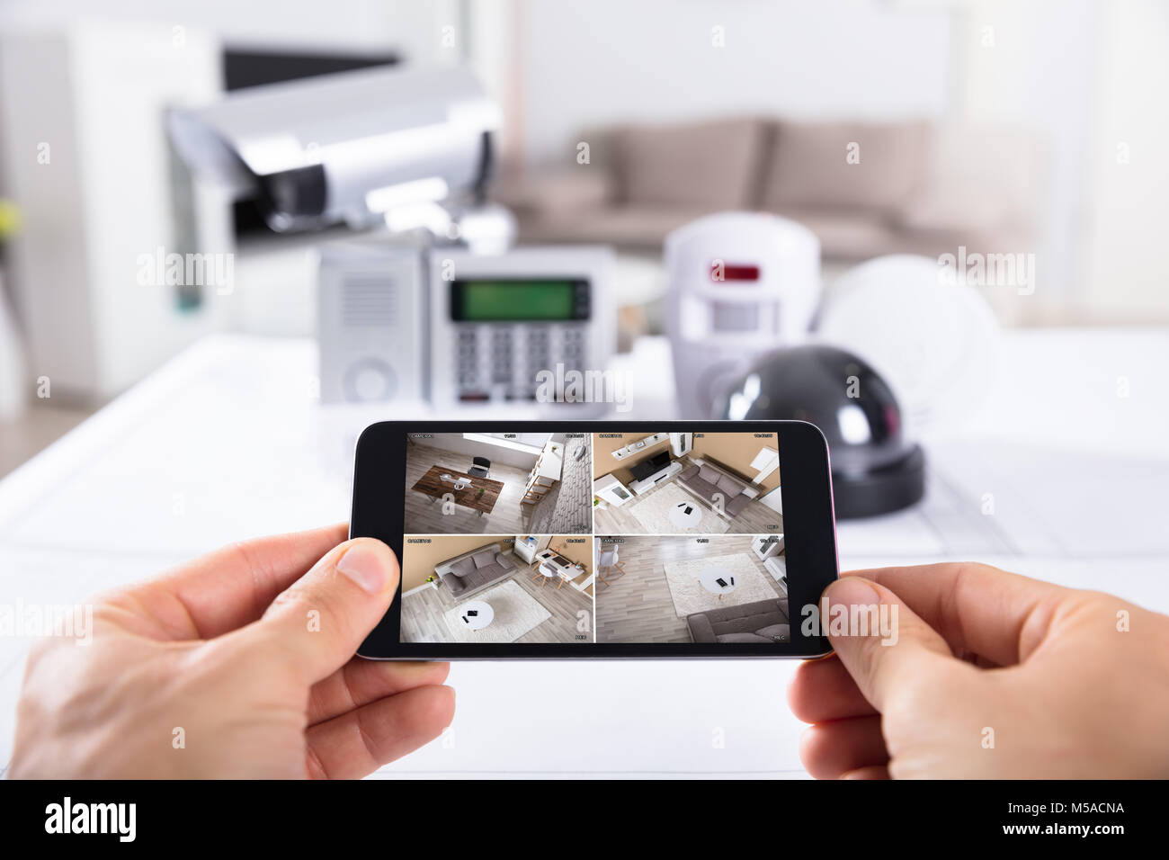 Close-up di una persona della mano che tiene il telefono cellulare con telecamera TVCC filmati sullo schermo Foto Stock