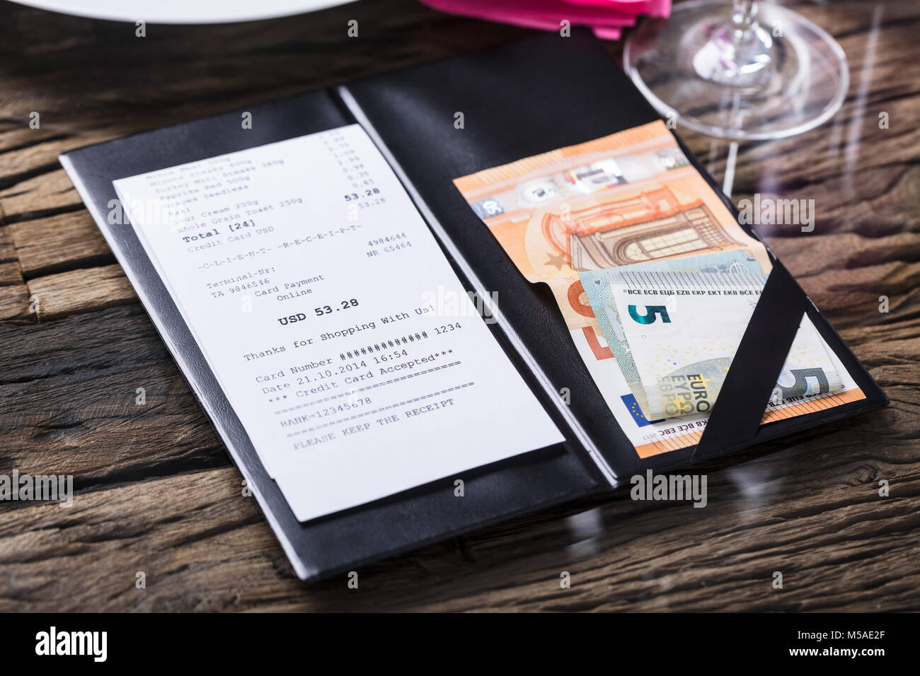 Vista in elevazione di Bill e la banconota sulla scrivania in legno Foto Stock