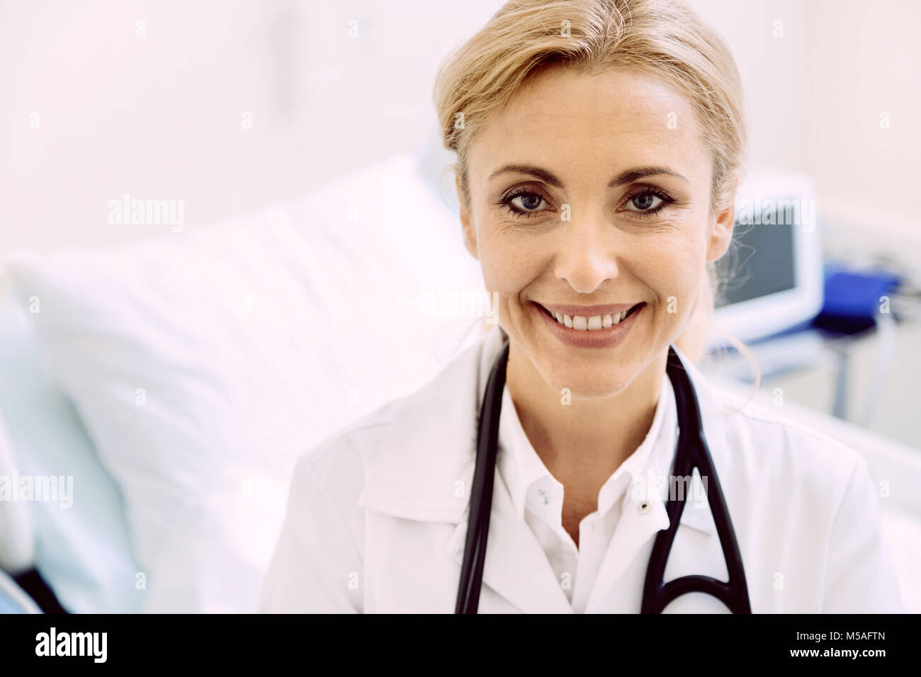 Allegro medico donna raggiante mentre guardando nella telecamera Foto Stock