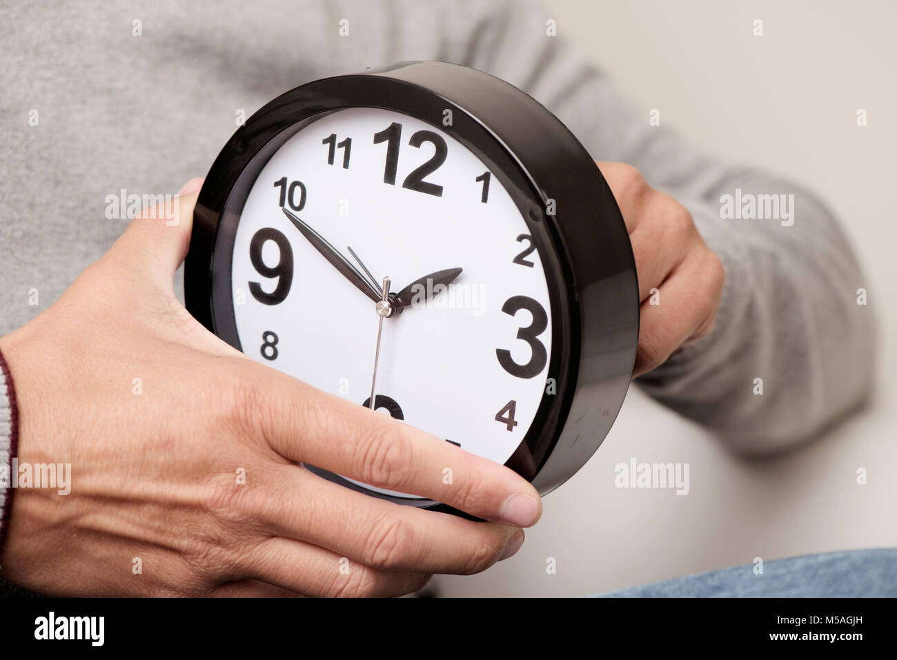 Primo piano di un giovane uomo caucasico regolando il tempo di un orologio Foto Stock