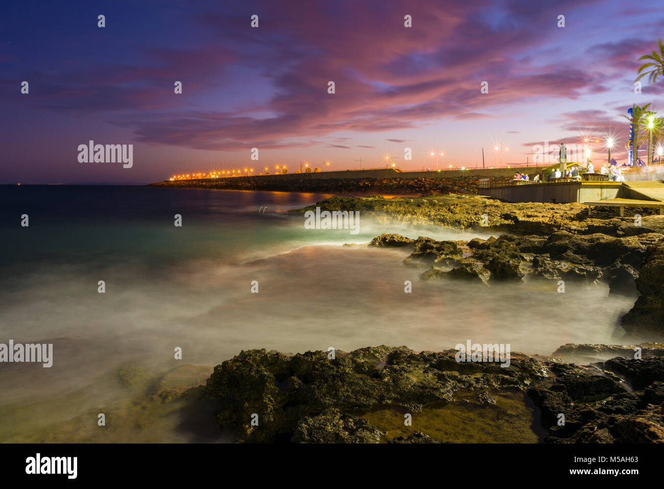Il lungomare di Torrevieja al tramonto con il molo frangiflutti e oltre. Provincia di Alicante, Spagna Foto Stock