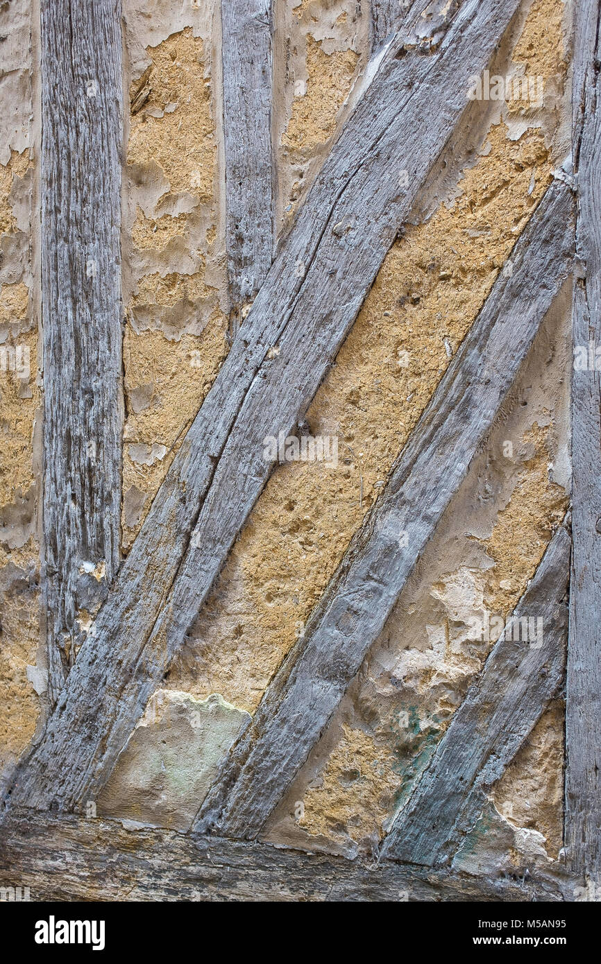 Dettaglio di una vecchia casa in legno e muratura con pareti sporche e legno stagionato , danneggiato in corrispondenza del fondo della parete, con muschio verde , Francia , Normandia. Foto Stock
