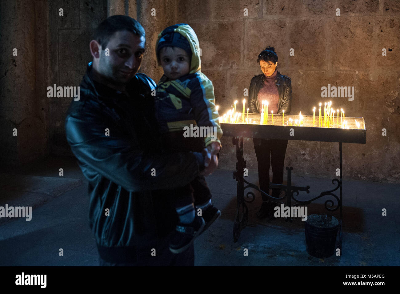 La famiglia sta offrendo alcune candele nel monastero Goshavank, Armenia. Foto Stock