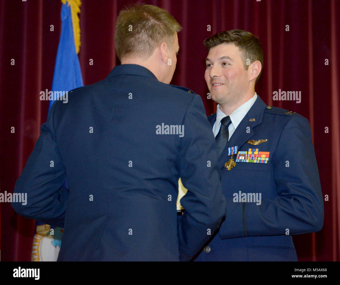 Stati Uniti Air Force Col. Lancia Schmidt, 752nd Special Operations Group commander, presenta Capt. Joshua Castro, sessantasettesima Special Operations Squadron MC-130J Commando II pilota, con illustri battenti croce con Valor a RAF Mildenhall, Inghilterra, 8 febbraio 2018. Due Air Commandos ha ricevuto il Distinguished Flying Cross con coraggio per il loro eroismo durante un rifornimento di aria durante la caduta sotto il fuoco nemico nella provincia di Helmand, Afghanistan, 5 gennaio 2016. (U.S. Air Force Foto Stock