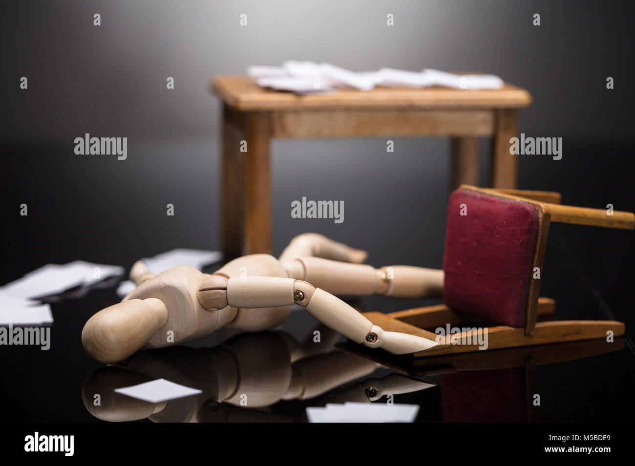 Inconscio manichino di legno la figura giacente sul piano con sparsi documenti al lavoro Foto Stock