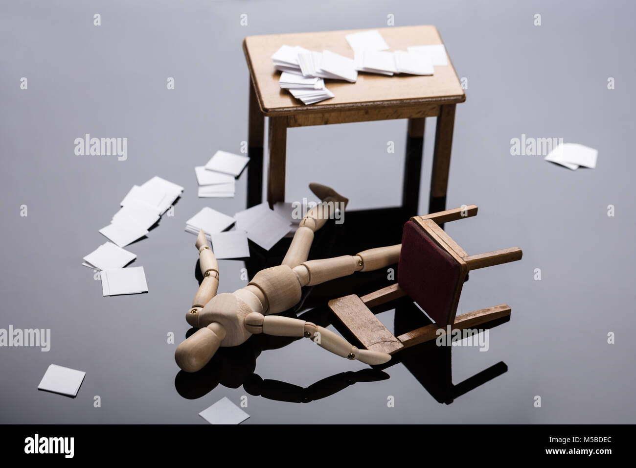 Inconscio manichino di legno la figura giacente sul piano con sparsi documenti al lavoro Foto Stock