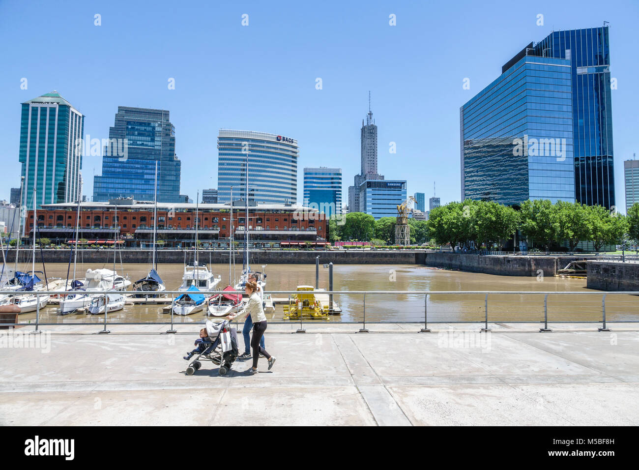 Buenos Aires Argentina,Puerto Madero,Rio Dique,acqua,lungofiume,skyline della città,edifici,ispanica,donna donna donne,uomo uomo maschio,passeggino spinta,ARG17 Foto Stock