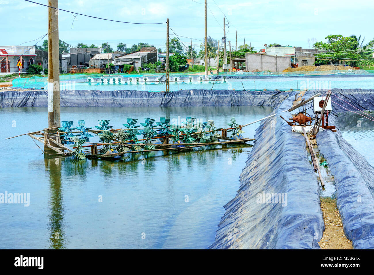 * Aeratore ruota di turbina ossigeno ins di riempimento nel lago di acqua in allevamento di gamberetti in Ba Ria, Vung Tau, Vietnam Foto Stock