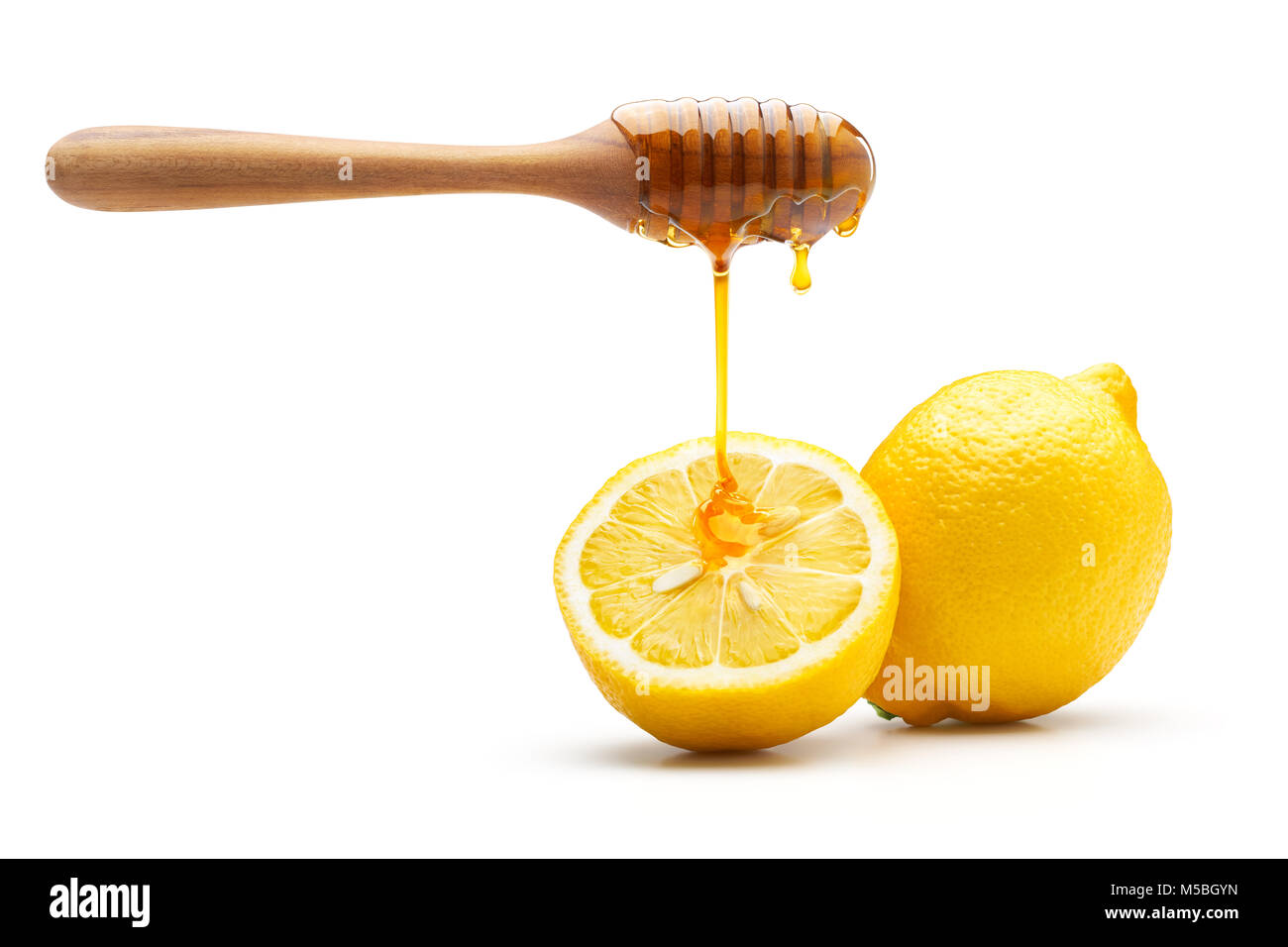 Il miele che gocciola sul limone fresco isolato su sfondo bianco Foto Stock