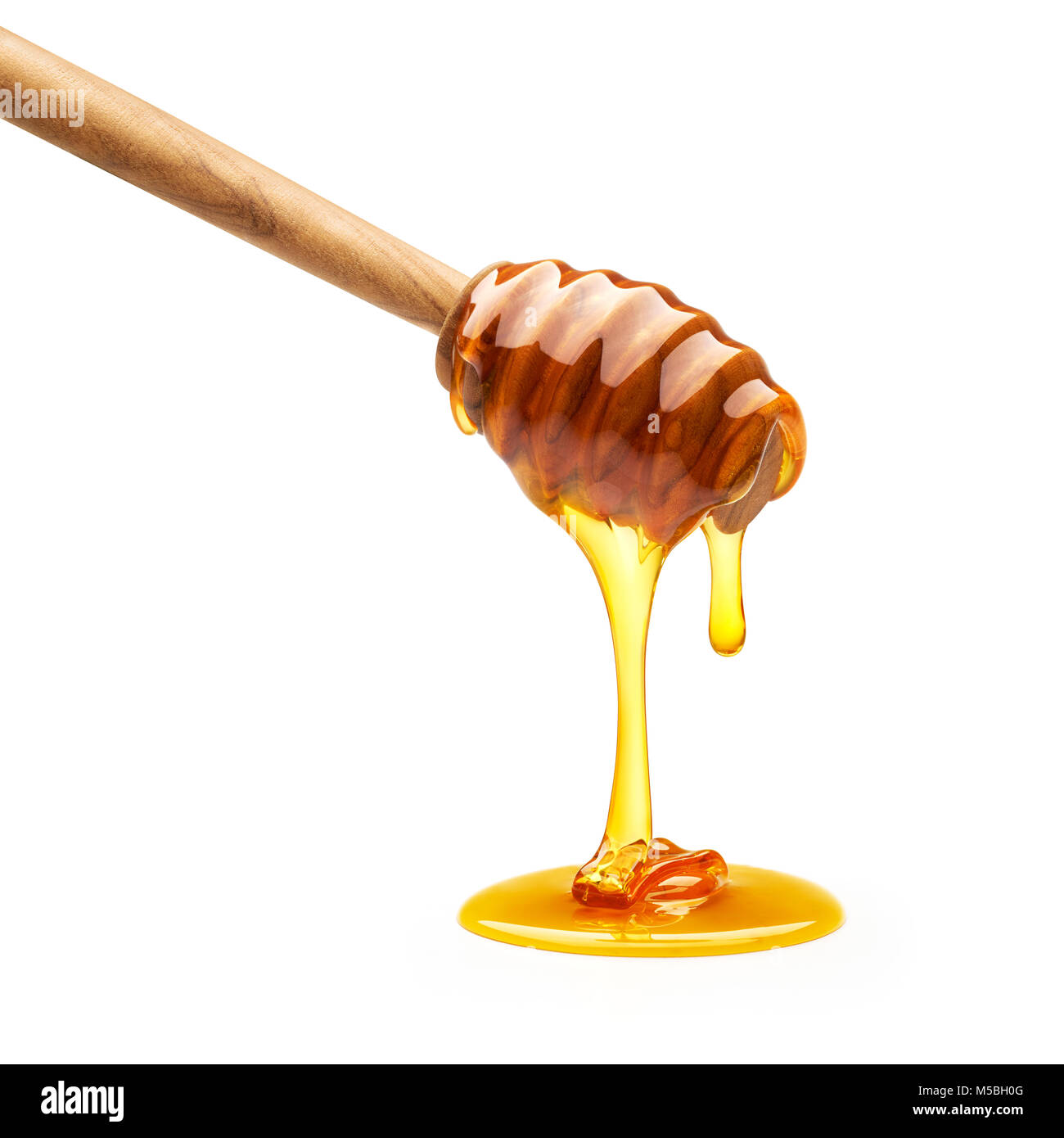 Il miele sgocciola dal bilanciere isolati su sfondo bianco Foto Stock
