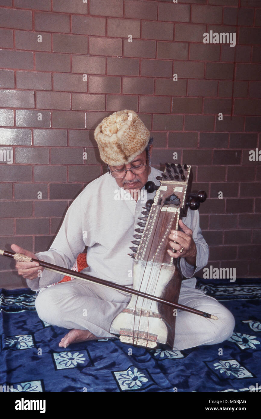 Un anziano di 80 anni, suonare uno strumento musicale Sarangi, India Foto Stock