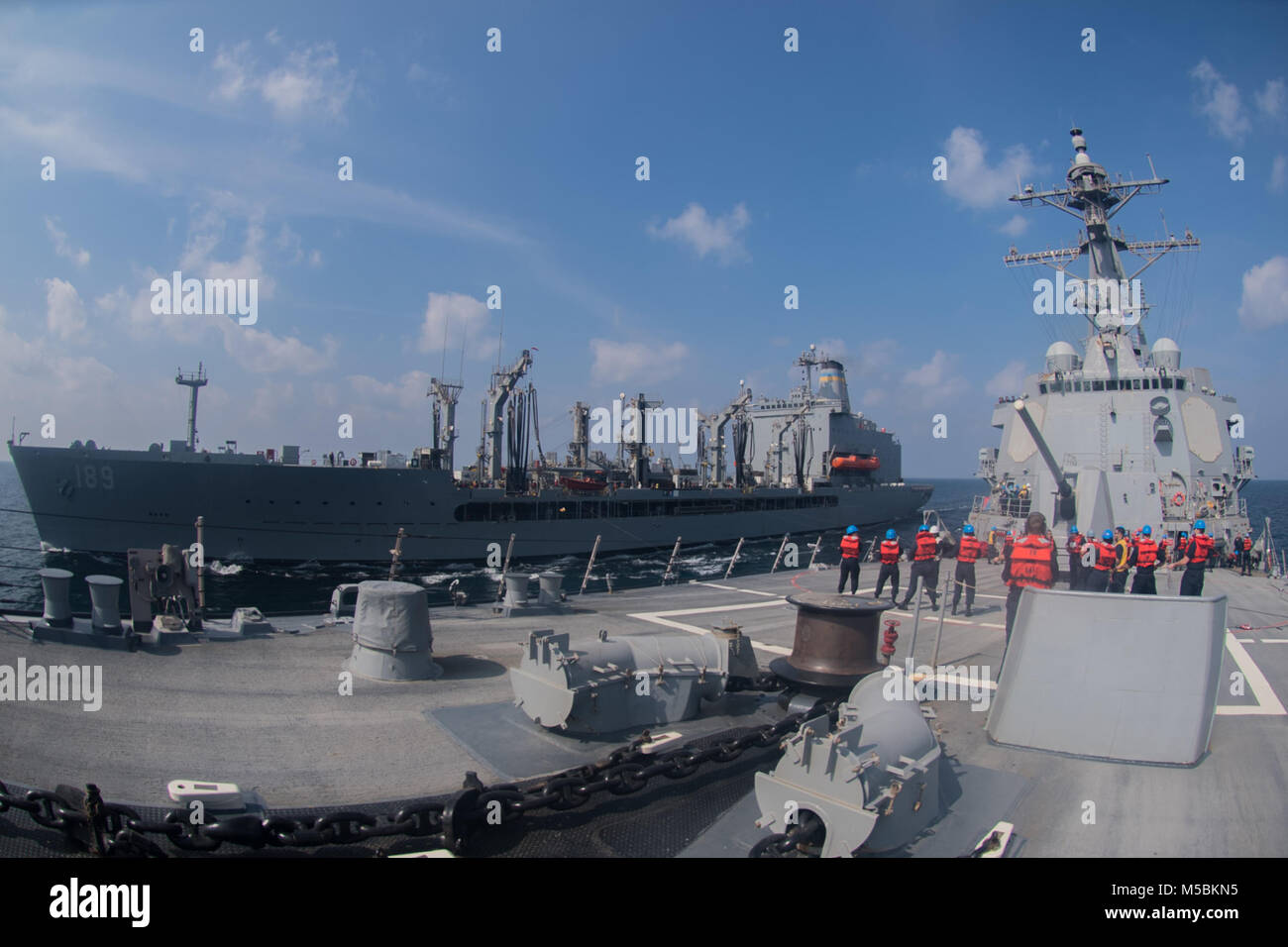 180213-N-AZ808-1146 Golfo di Oman (feb. 13, 2018) Il Arleigh Burke-class guidato-missile destroyer USS Halsey (DDG 97) conduce a una ricostituzione in mare con la flotta di rifornimento USNS oliatore John Lenthall (T-AO 189). Halsey viene implementato con Theodore Roosevelt Carrier Strike gruppo per gli Stati Uniti Quinta Flotta area di operazioni a sostegno della sicurezza marittima operazioni per rassicurare gli alleati e partner e preservare la libertà di navigazione e il libero flusso di commercio nella regione. (U.S. Foto di Marina di Massa lo specialista di comunicazione di terza classe Nicholas Burgains/rilasciato) Foto Stock