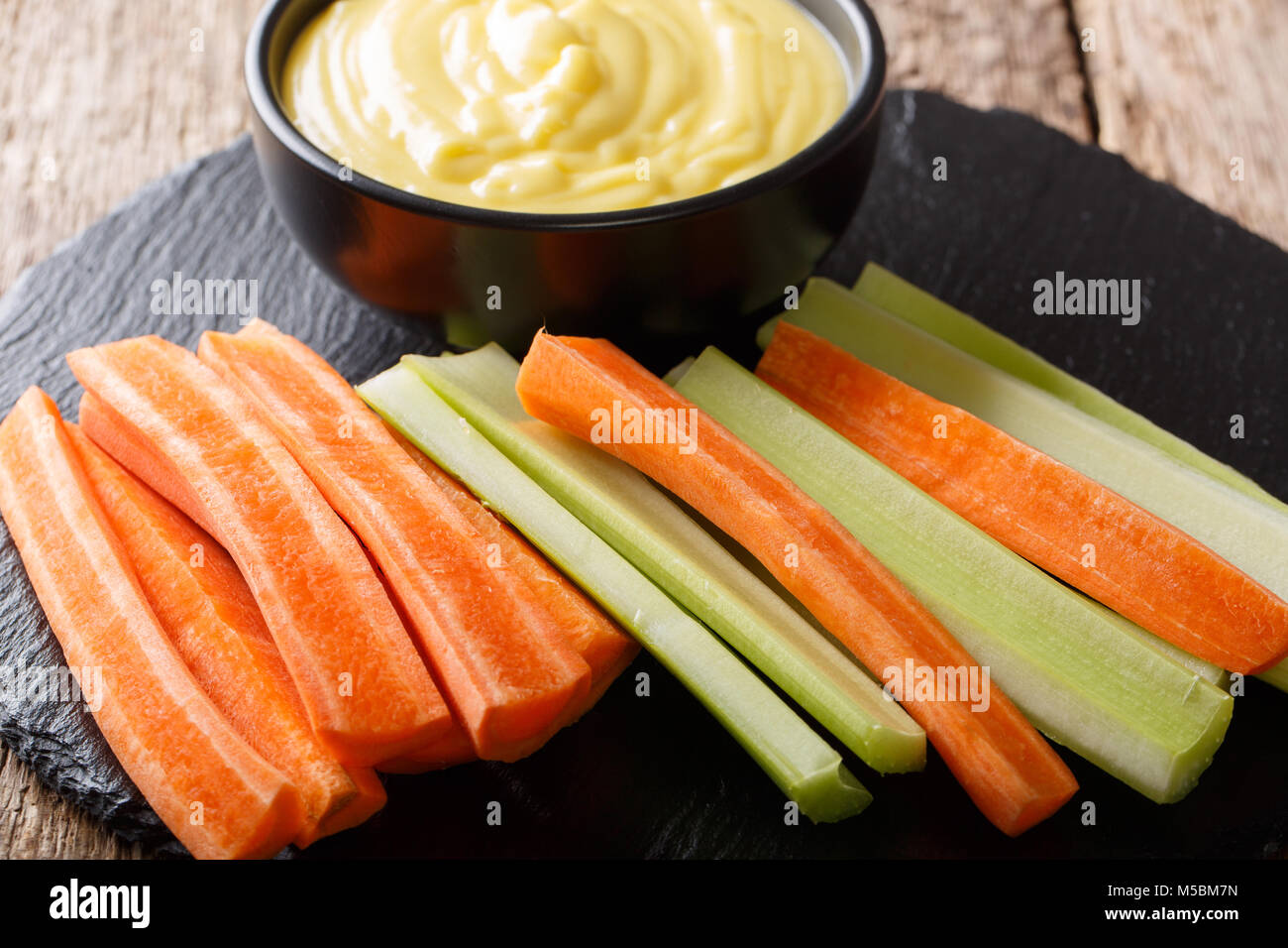 Crudo fresco il sedano e le carote e crema di formaggio dip salsa vicino sul tavolo orizzontale. Foto Stock