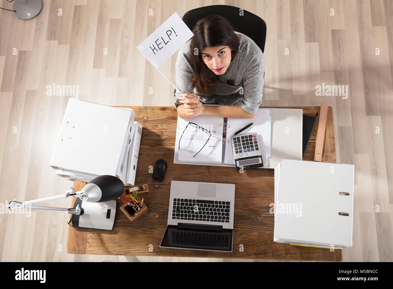 Vista in elevazione di una imprenditrice che mostra consentono di bandiera al lavoro in ufficio Foto Stock