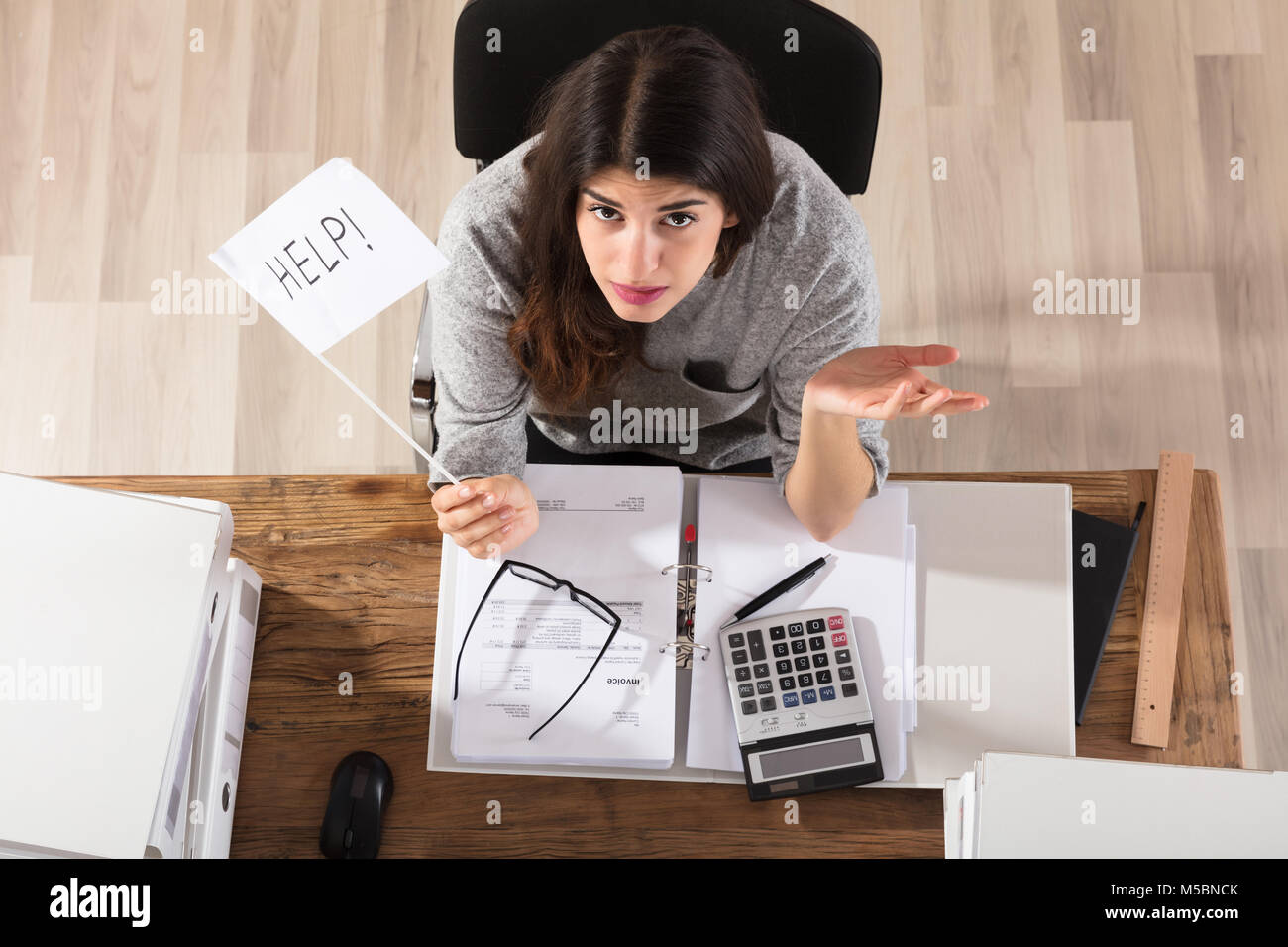 Vista in elevazione di una imprenditrice che mostra consentono di bandiera al lavoro in ufficio Foto Stock