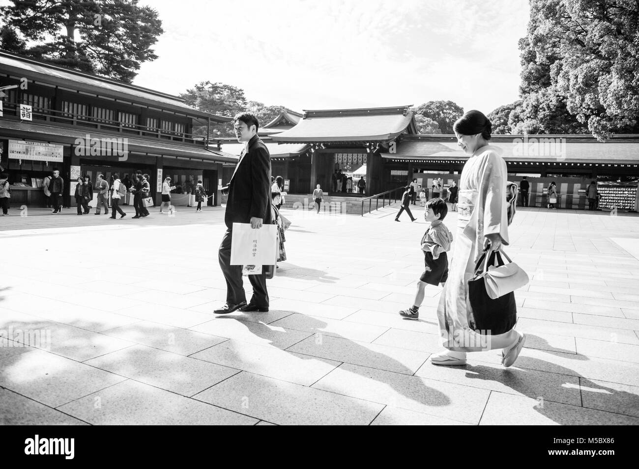 Una famiglia passeggiate attraverso i motivi di Meiji Jingu durante la Gran festa d autunno Foto Stock