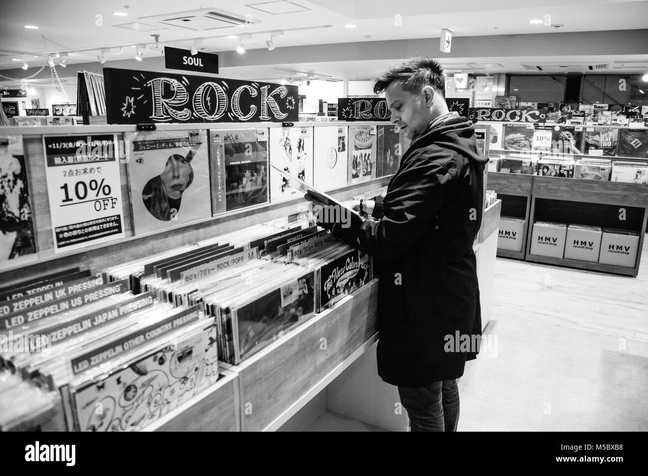 Un uomo caucasico negozi per i record in un negozio di musica a Shinjuku, Tokyo Foto Stock