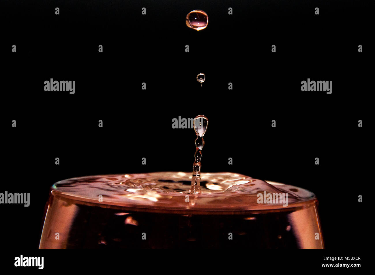 Rosso vino goccia splash sfondo nero Foto Stock