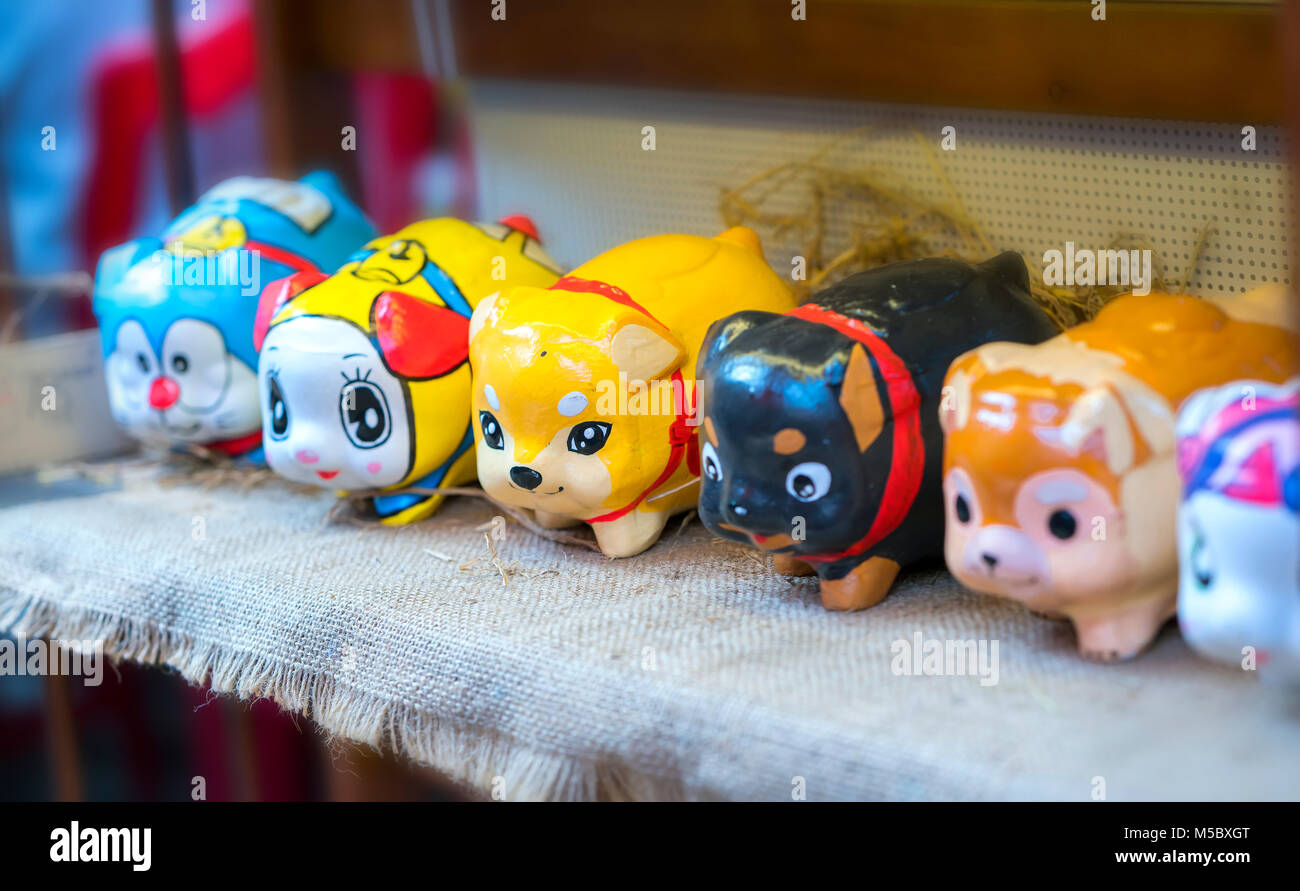 Il coloratissimo salvadanaio visualizzato presso la Fiera di Primavera per dare ai bambini i risparmi sono la dogana di cultura orientale mantenuto oggi. Foto Stock