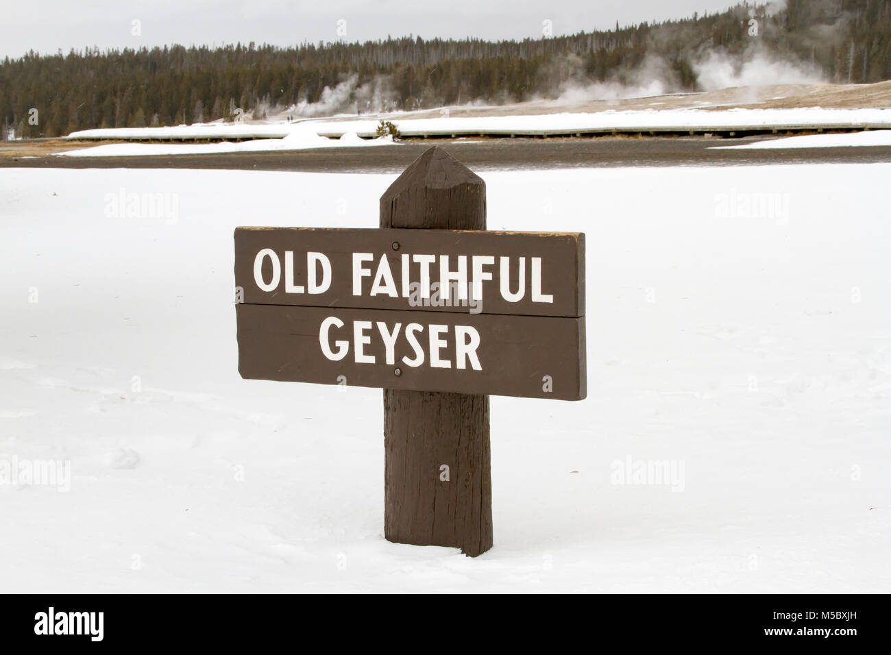 Cartello in legno per il geyser Old Faithful nel Parco Nazionale di Yellowstone, Wyoming in inverno. Foto Stock