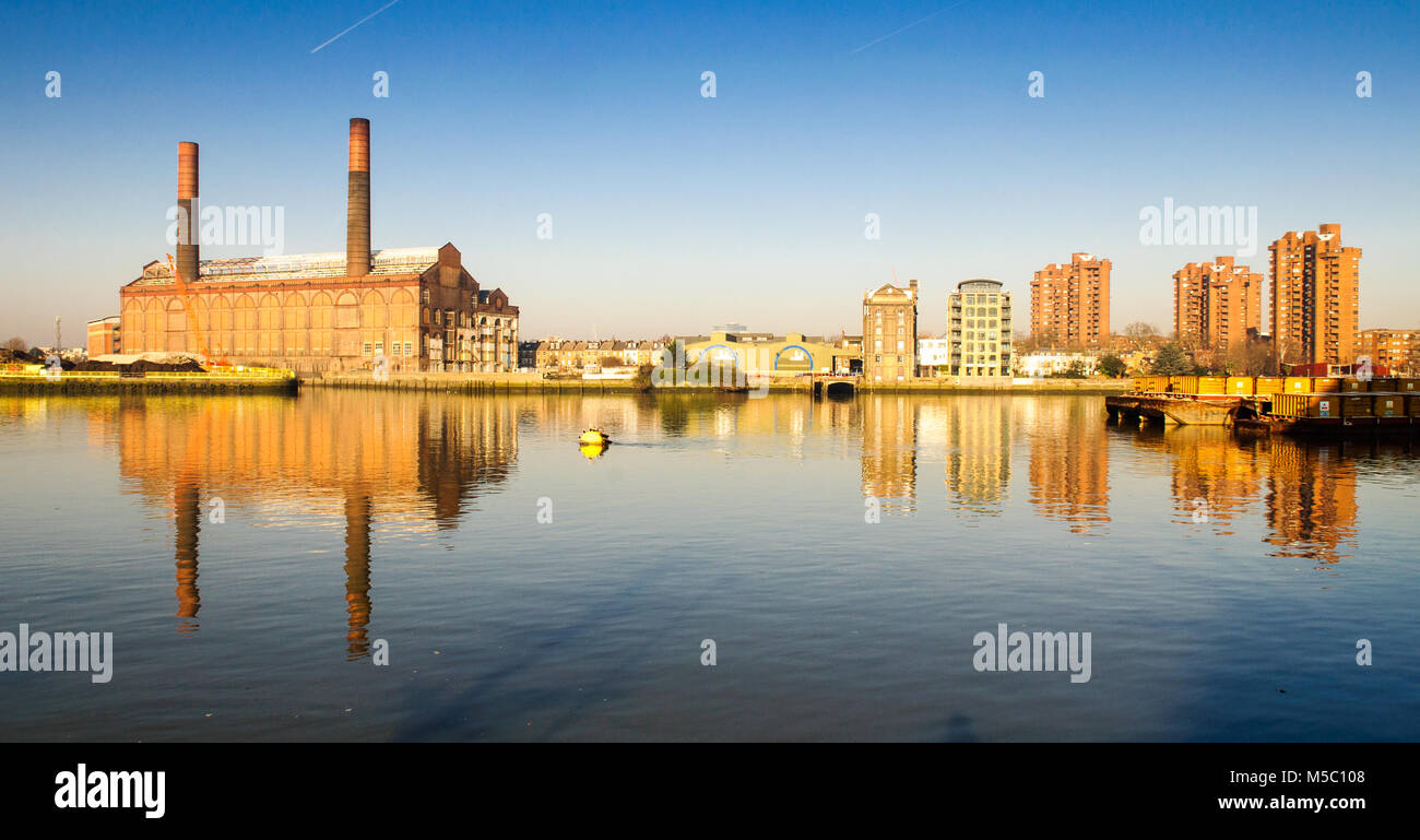 Un sacco di strada della stazione di alimentazione e la fine del mondo alto consiglio estate sono riflesse nelle acque del fiume Tamigi a Chelsea nella zona ovest di Londra. Foto Stock