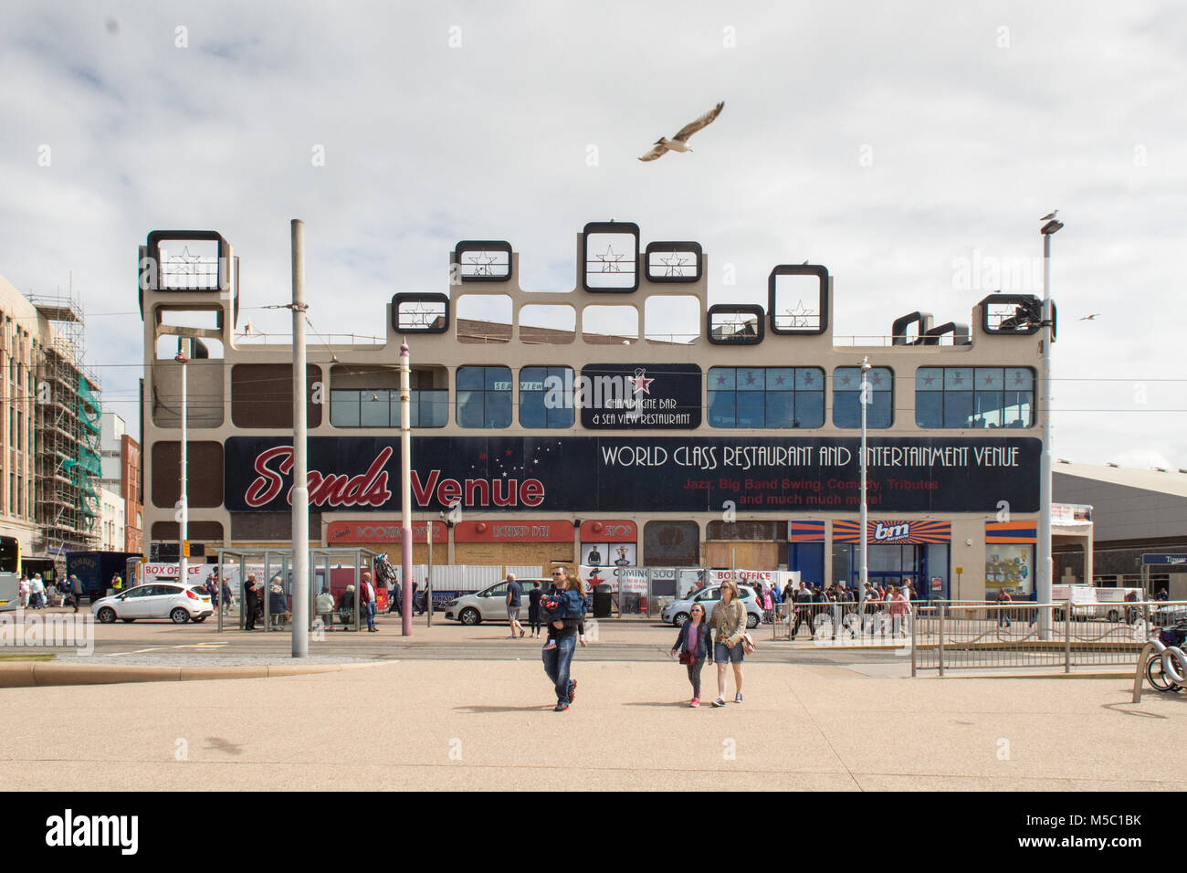 Blackpool, Inghilterra, Regno Unito - 1 Agosto 2015: i turisti a piedi lungo la Promenade di Blackpool fuori le sabbie Venue cabaret club. Foto Stock