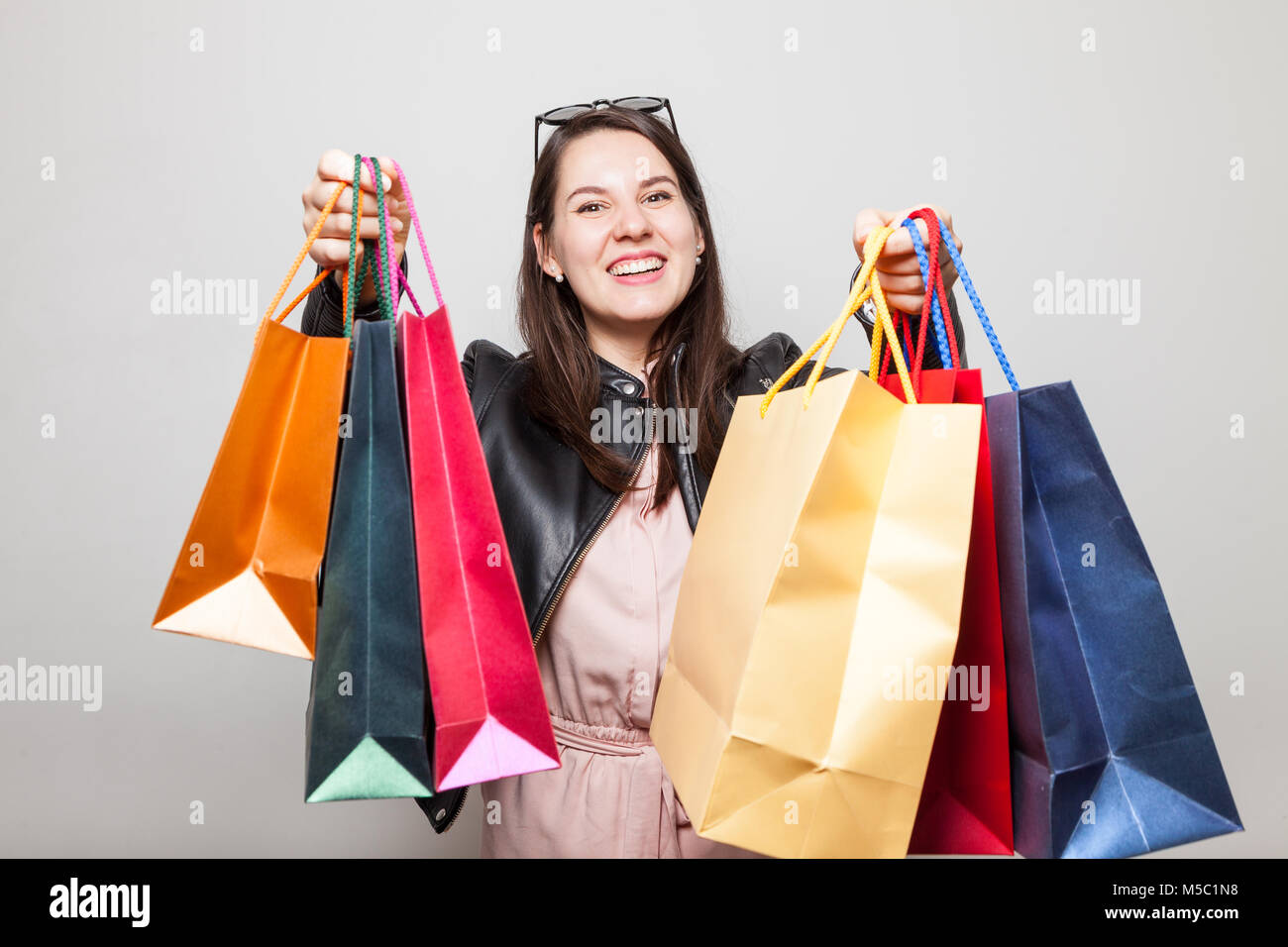 Bella risata ragazza caucasica stende il colore delle borse per lo shopping Foto Stock