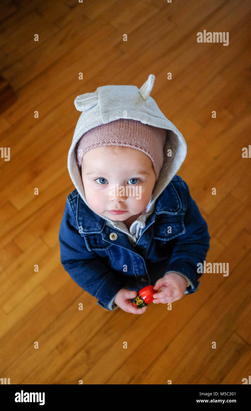 Carino femmina toddler bambino a casa vestito in costume caldo abbigliamento con il cofano Foto Stock