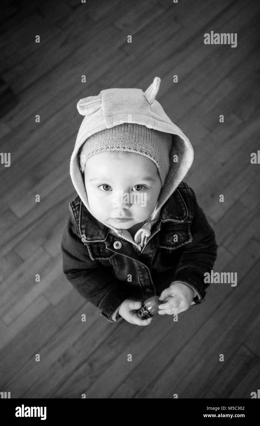 Carino femmina toddler bambino a casa vestito in costume caldo abbigliamento con il cofano Foto Stock