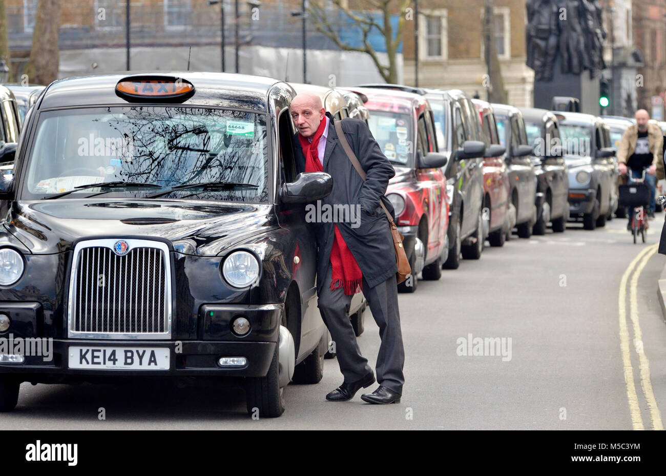 Londra, Inghilterra, Regno Unito. Uomo che parla di un Black Cab Driver durante una manifestazione di protesta contro la Uber app Foto Stock