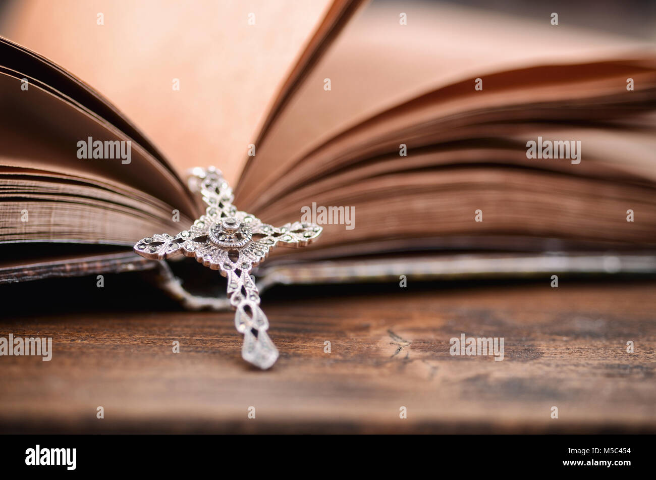 Una croce cristiana collana su una Sacra Bibbia, il cristianesimo e la religione del concetto. Foto Stock