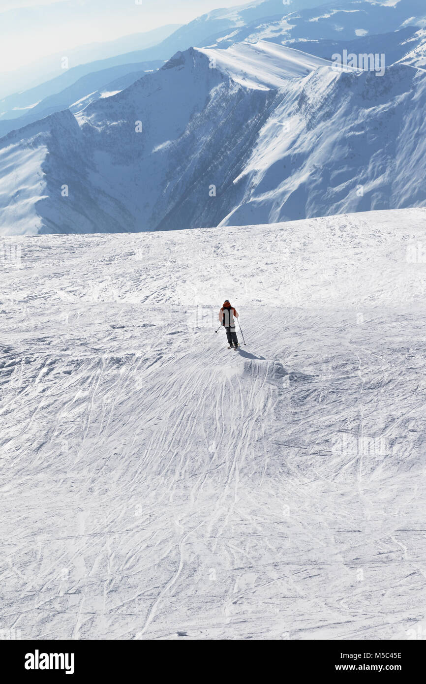 Silhouette di sciatore in discesa su pendio nevoso per il freeride in sun giorno d'inverno. Montagne del Caucaso, Georgia, regione Gudauri. Foto Stock