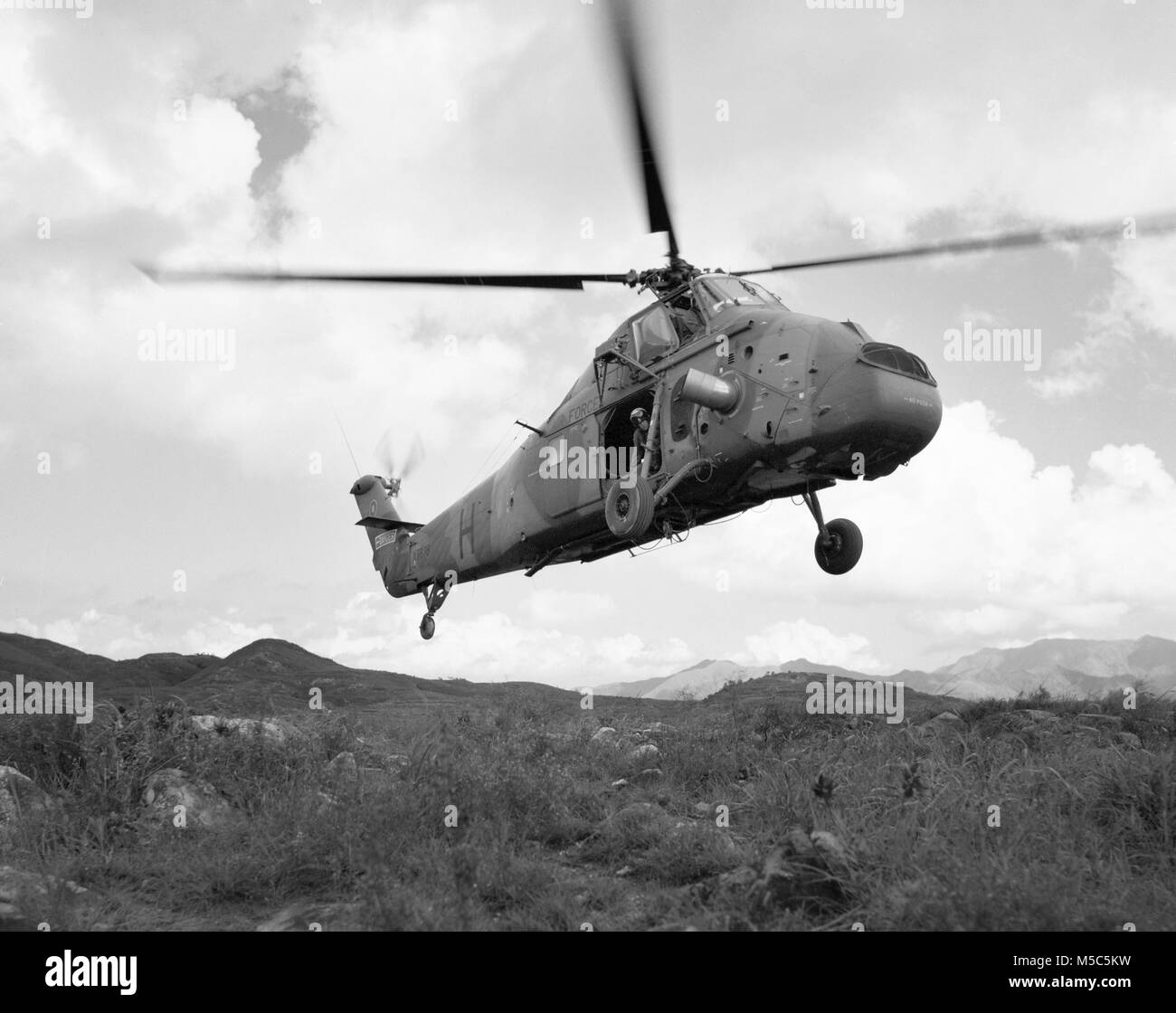 RAF Westland Wessex elicottero di 28 Sqn sollevare in terreno montuoso, Lantau, Hong Kong. Foto Stock