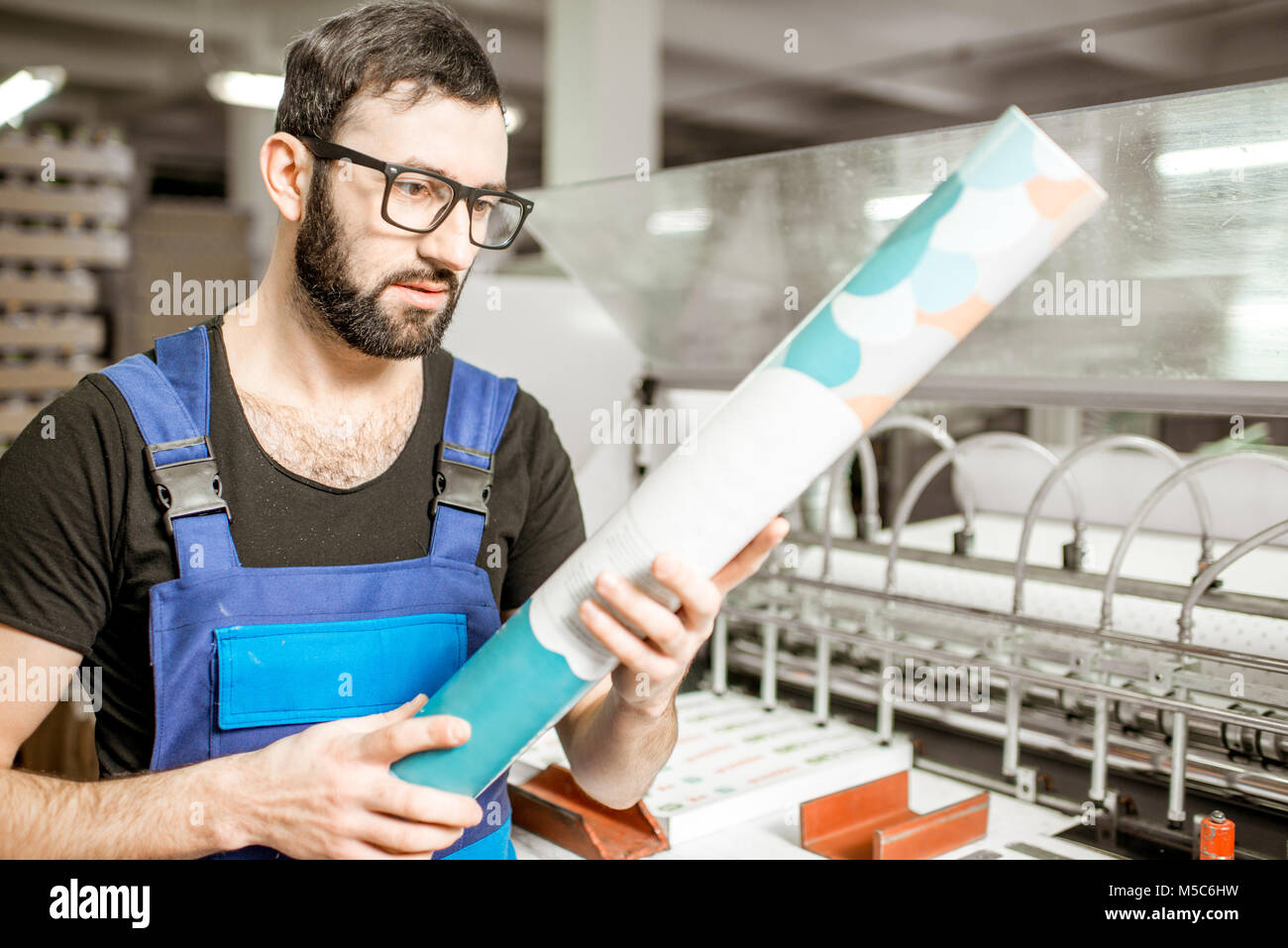 Uomo con tubo di carta a livello di fabbricazione Foto Stock